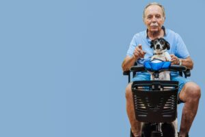 Senior riding an electric scooter on a paved path, showcasing ease of mobility and independence.